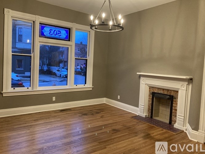 A room with a fireplace and a chandelier is available for rent.