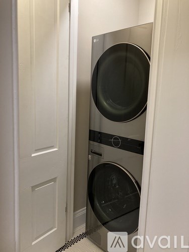 A washing machine is built into a wall in a small room.