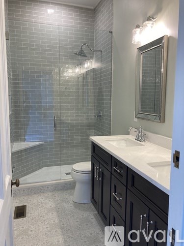 A bathroom with a toilet, sink, and shower.