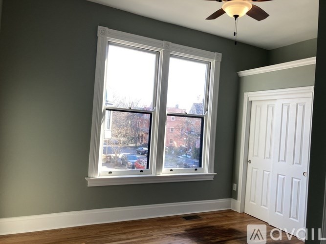 A room with a window and a ceiling fan.