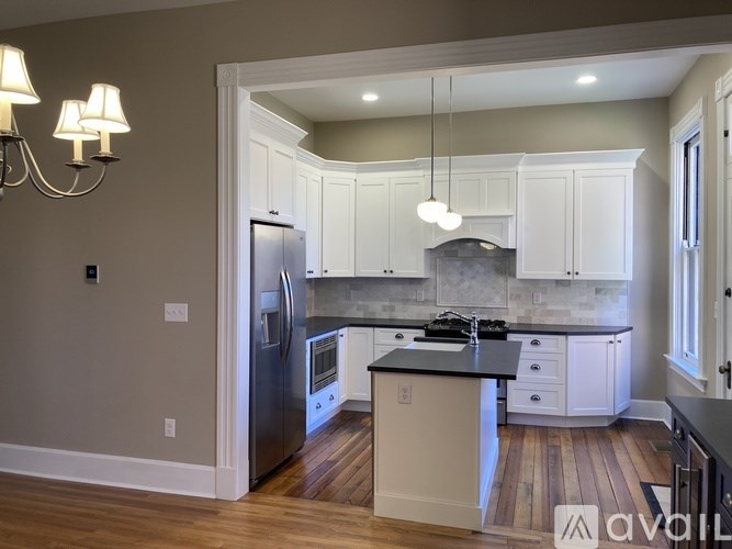 A kitchen with a refrigerator, stove, and cabinets.