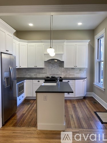 A kitchen with a black countertop and white cabinets.
