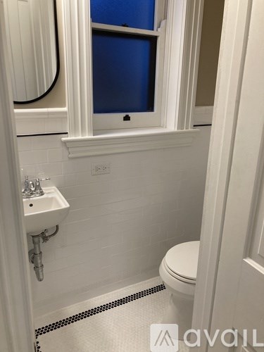 A white toilet sits next to a sink in a bathroom.