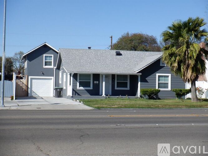 A house with a garage and a driveway in front.