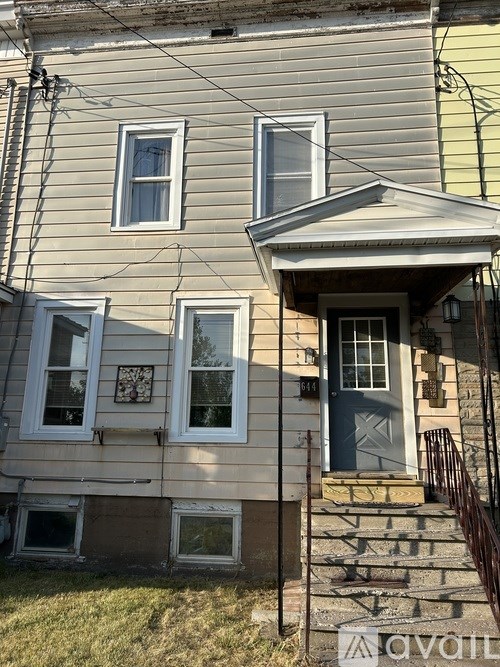 A house with a blue door and a window with a white frame.