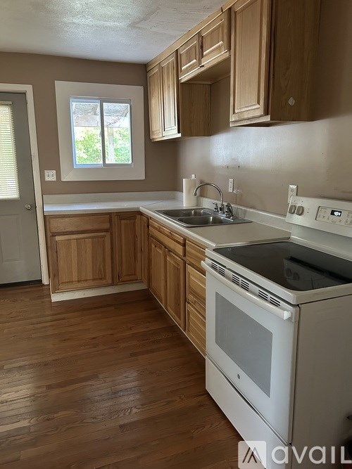 A kitchen with wooden cabinets and a white oven.