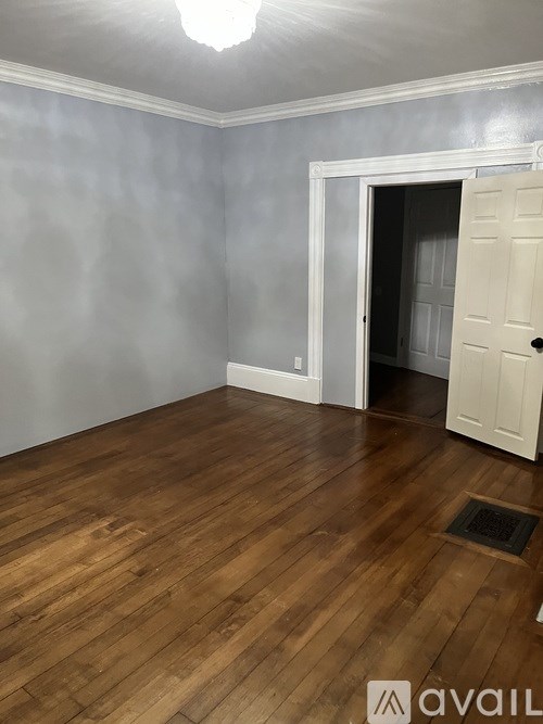 A room with wooden floors and a white door.