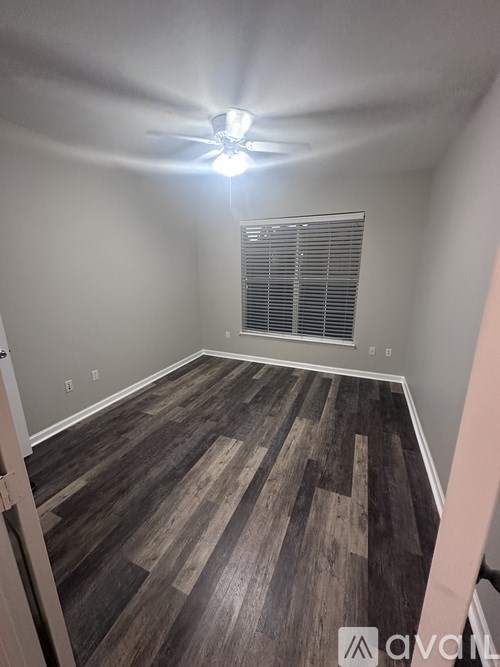 A room with wooden flooring and a ceiling fan.