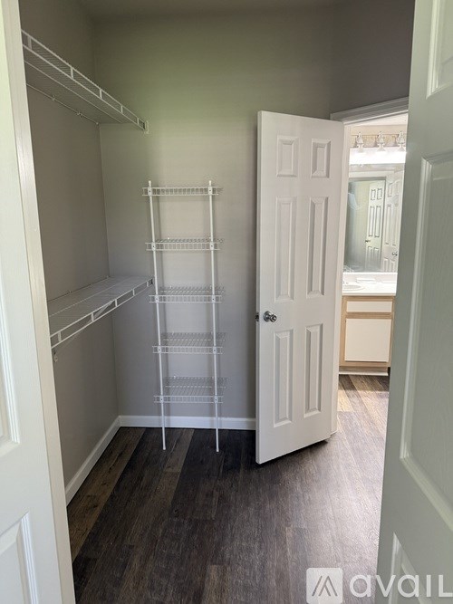 A white door is open to a room with a white wall and a white floor.