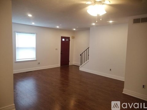 A room with a wooden floor and a red door.