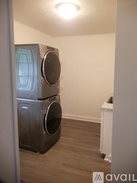A stack of three washing machines in a laundry room.