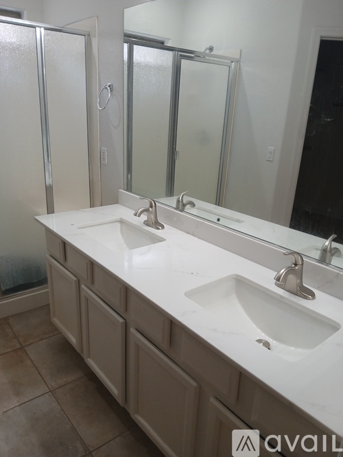 A bathroom with a white counter top and two sinks.
