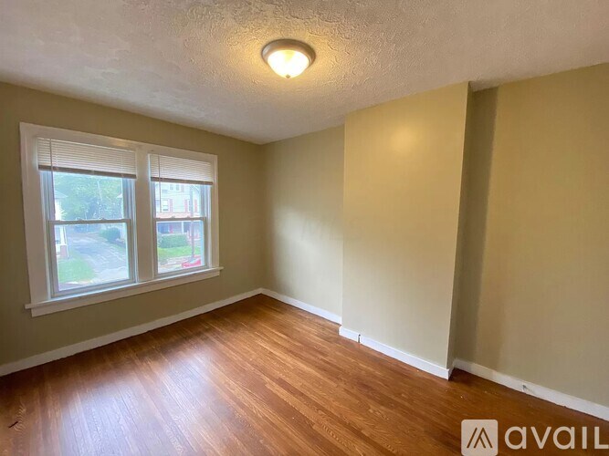 A room with a window and wooden flooring.