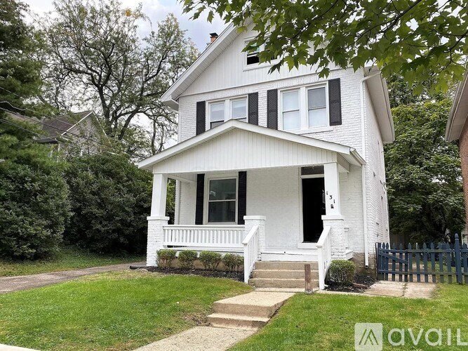 A white house with a black fence in front.