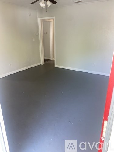 A room with a ceiling fan and a door.