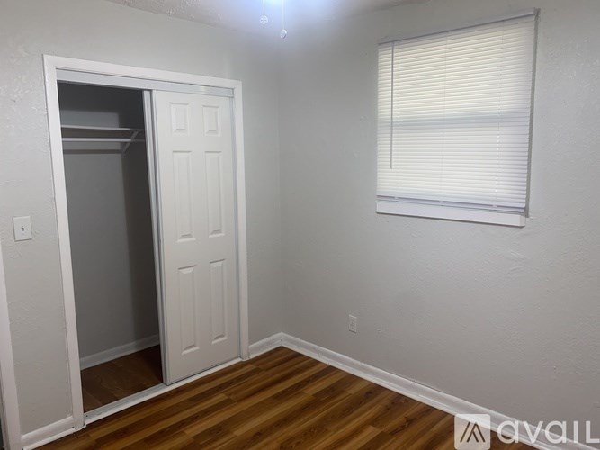 A room with a white door and a window with blinds.