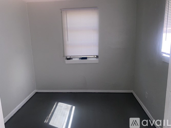 A room with a window and a white wall.