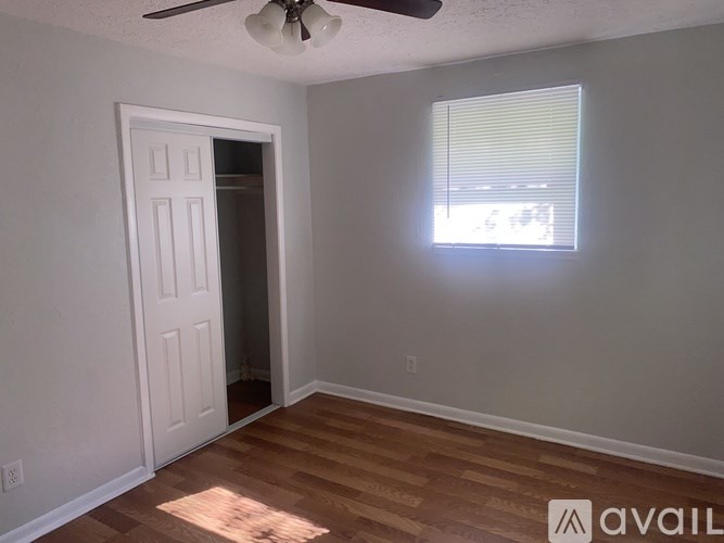 A room with a white door and a window with blinds.