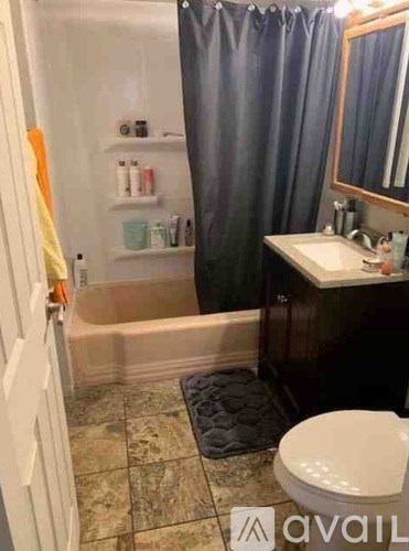 A bathroom with a white toilet, a sink, and a shower.