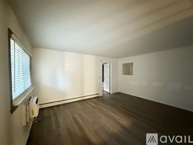 A room with a bed, a ceiling fan, and a window with blinds.