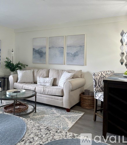 A living room with a white couch and a glass coffee table.