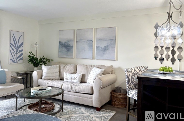 A living room with a white couch and a glass coffee table.
