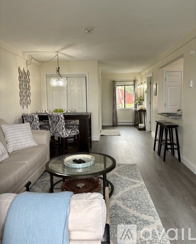 A living room with a glass table and a sofa.