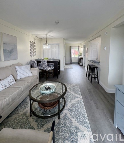 A living room with a sofa, coffee table, and a rug.