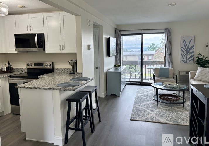 A kitchen with white cabinets and a granite countertop.