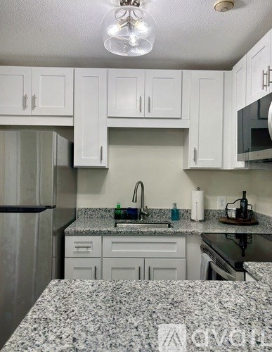 A kitchen with granite countertops and white cabinets.