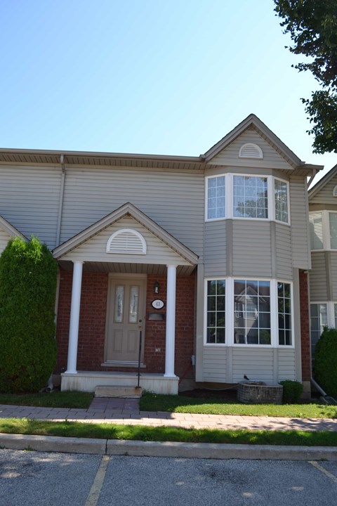A house with a brown door and a grey roof.