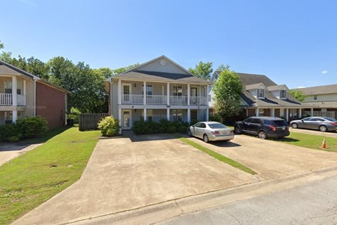 A sunny day at a residential area with houses and cars.