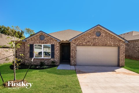 A brick house with a garage door is for sale.
