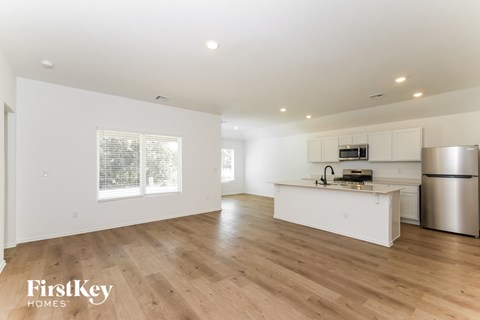A kitchen with wooden floors and white walls.