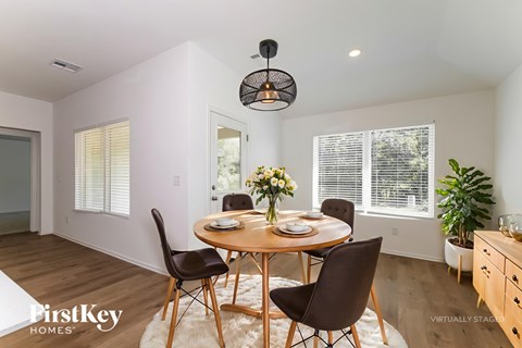 A dining room with a round table and chairs.