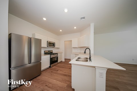 A kitchen with a stainless steel refrigerator and a white countertop.