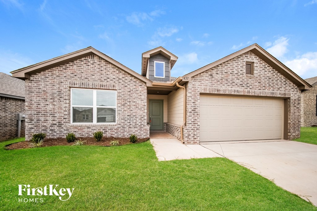 A brick house with a garage door and a window.