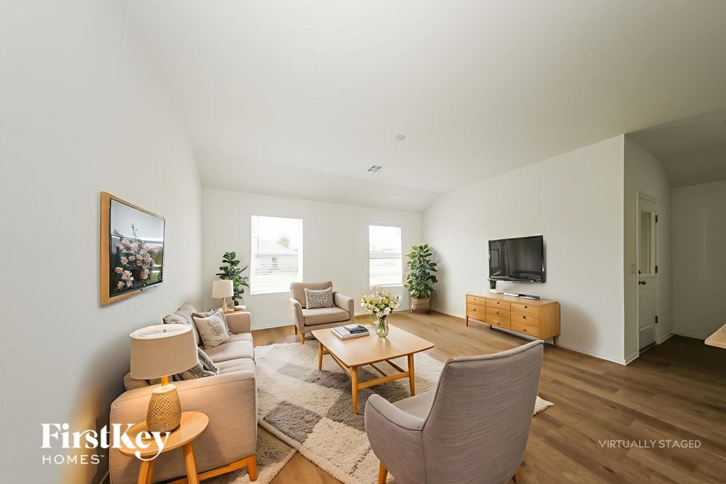 A living room with a couch, chair, and a television.
