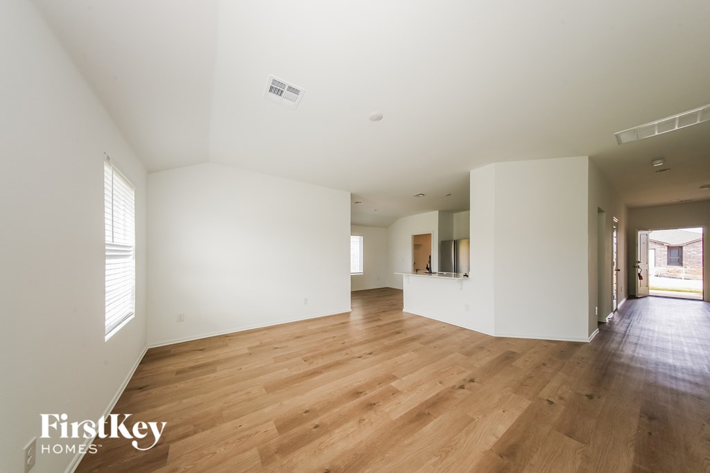A large empty room with wooden floors and white walls.