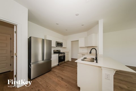 A kitchen with a stainless steel refrigerator and a white countertop.