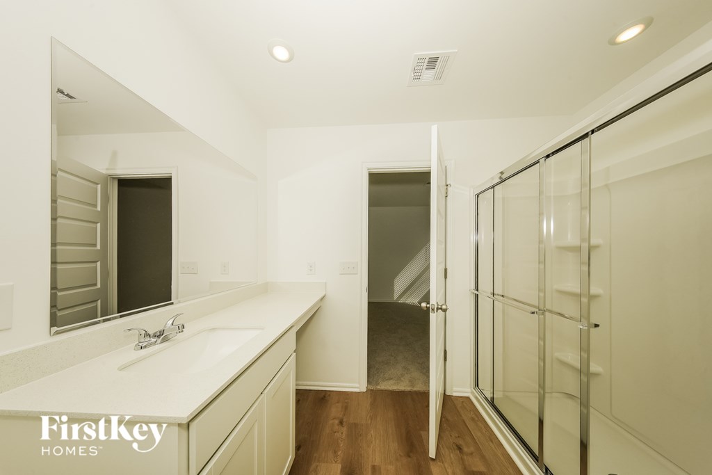 A bathroom with a white sink and a mirror.