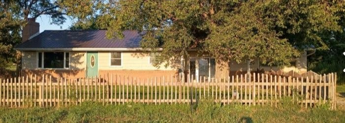 A house with a green door and a wooden fence.