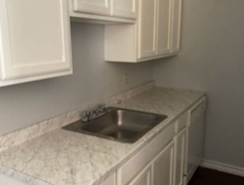 A kitchen with a sink and cabinets.