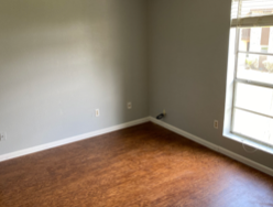 A room with a window and wooden floors.