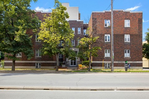 A red brick building with trees in front.