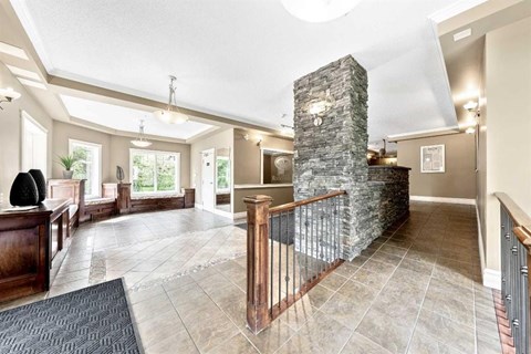 A large open living room with a stone pillar and a balcony.
