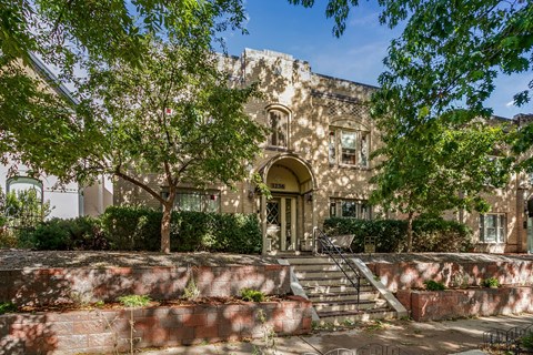 A large house with a tree in front of it.
