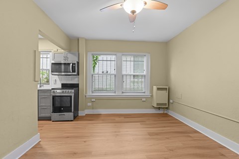 A kitchen with a microwave, oven, and a window.