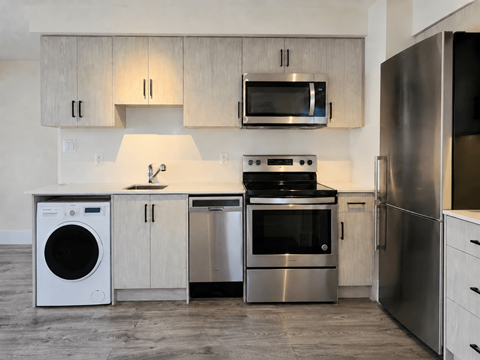 A modern kitchen with stainless steel appliances and wooden cabinets.