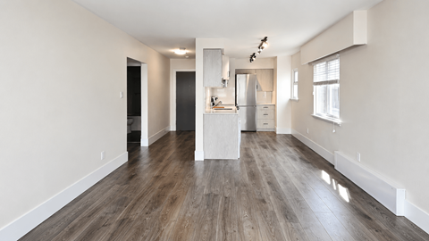 A spacious kitchen with a refrigerator, sink, and cabinets is visible.